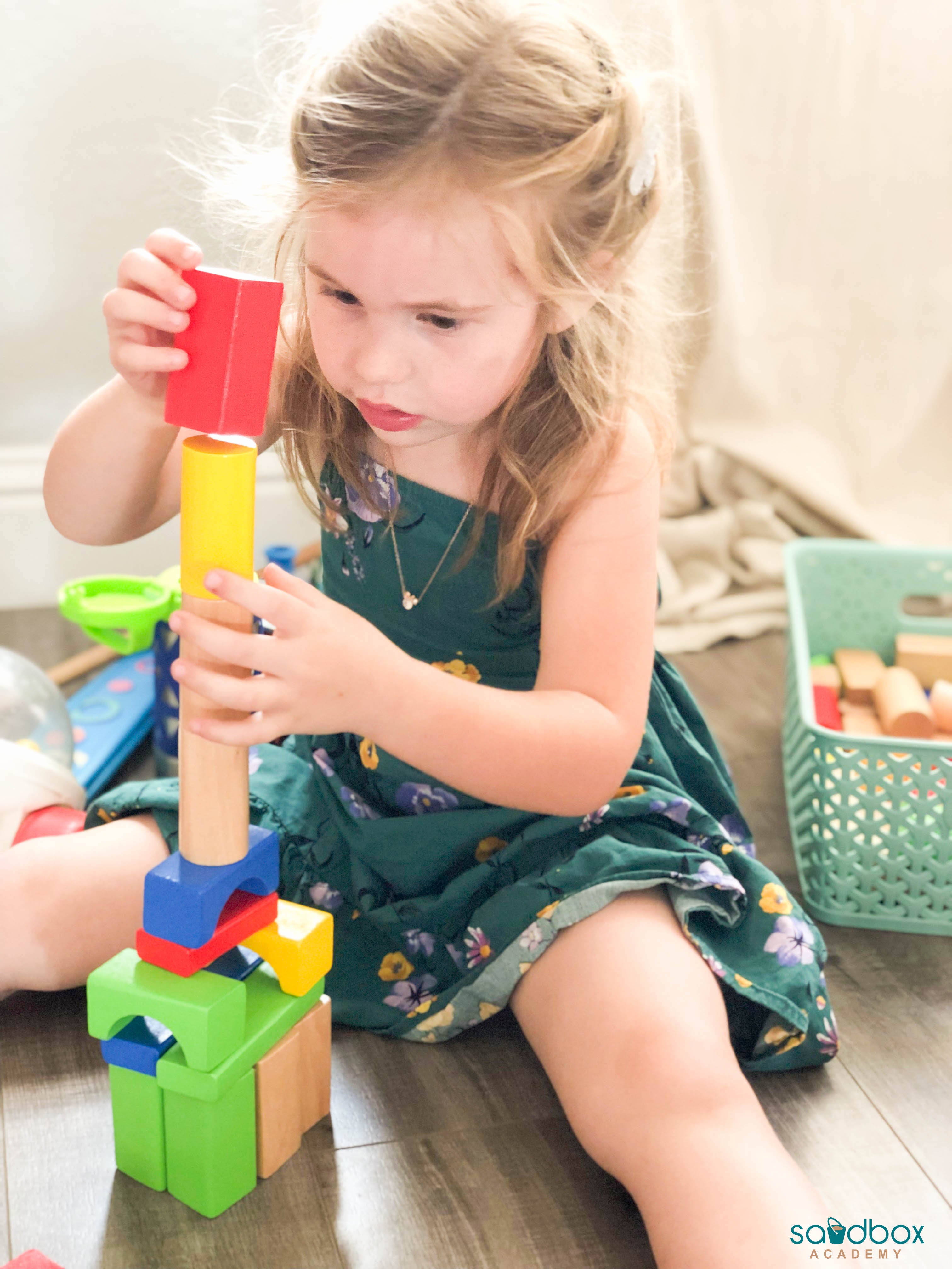 4 year old girl building a tower with blocks