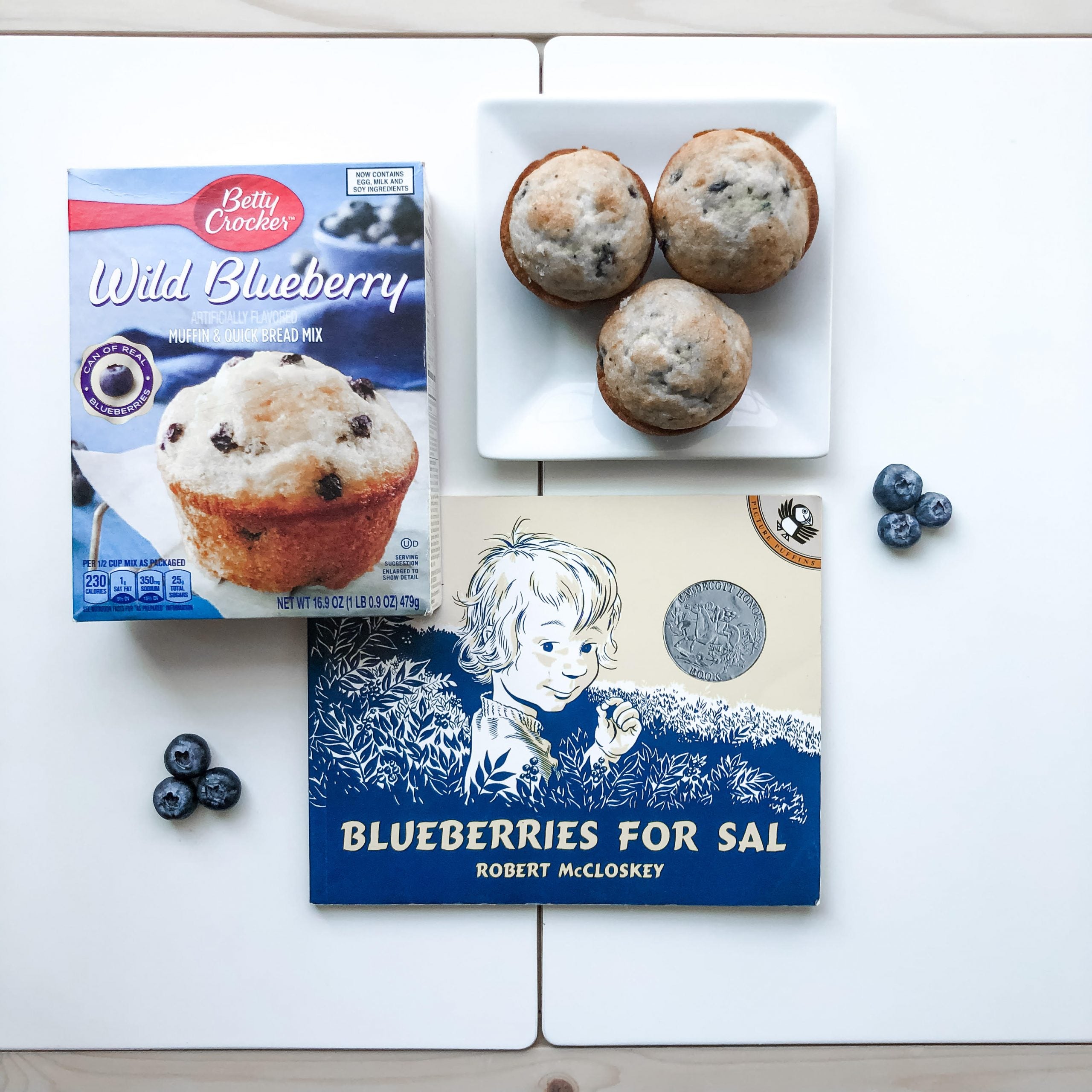 blueberry muffins, blueberry muffin mix, and the book blueberries for sal to show how baking is a form of bookish play