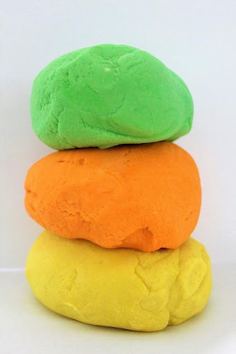 piles of green, orange, and yellow play dough used to help kids de